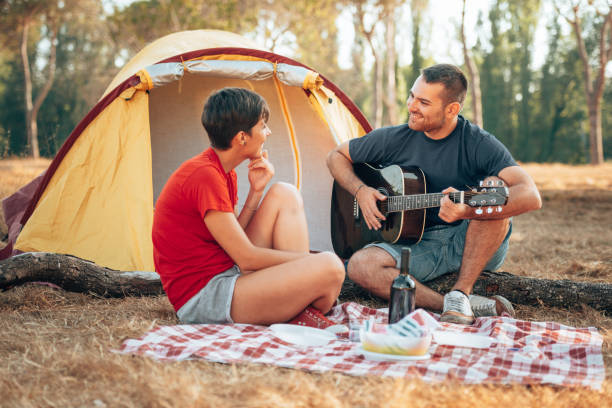 istock playing the guitar at the camping 1312920197
