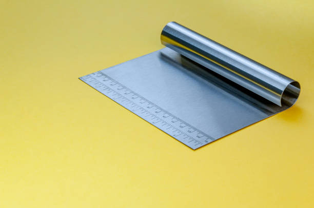 Metal Dough Scraper Knife Over Bright Yellow Surface Background