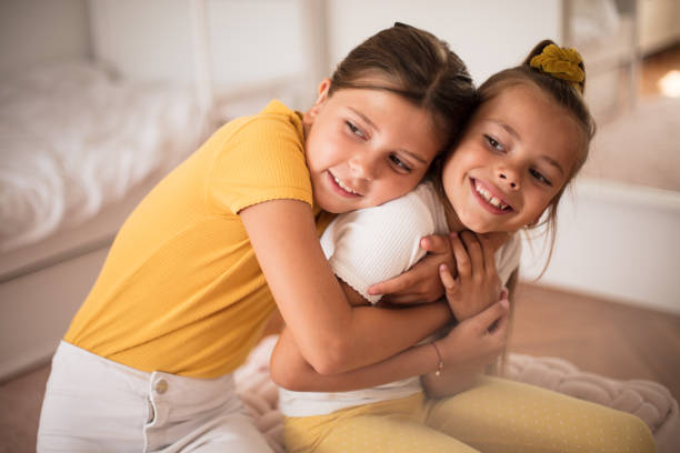 istock Kids at home. Sisters in hug. 1312923680