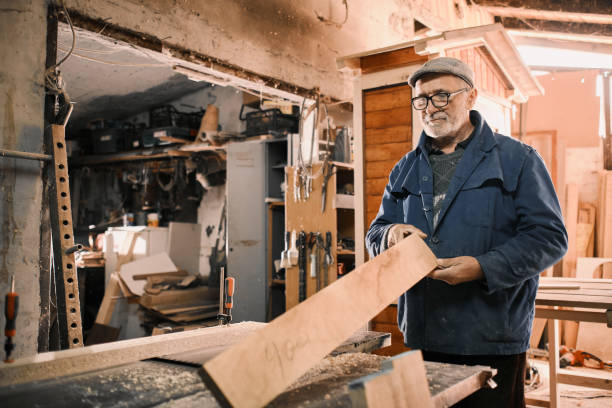 istock An old carpenter, he is working on a wooden board in an old workshop. 1312927130
