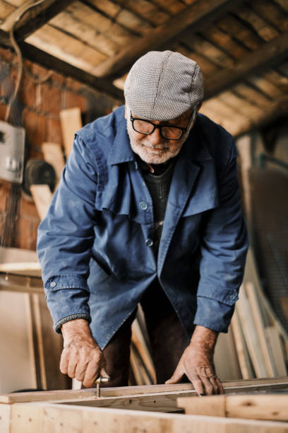 istock An old carpenter, he screws into a wood in an old workshop. 1312928045