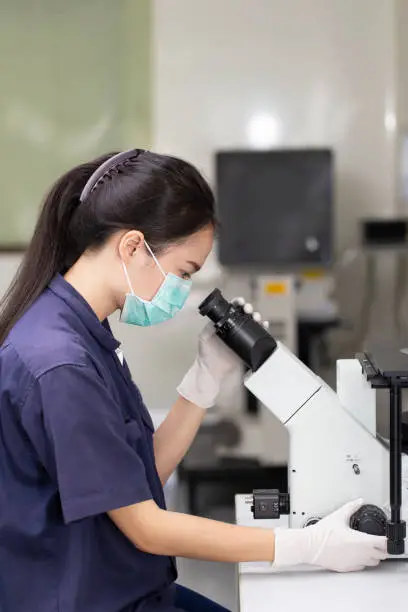 Photo of Scientist looking in microscope in laboratory microscope, Coronavirus covid-19, bacteriology, virology, dna and health care.