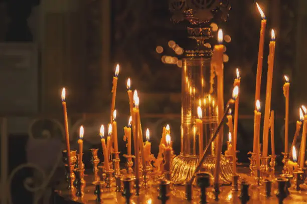 Photo of Many burning wax candles in orthodox church or temple for ceremony easter