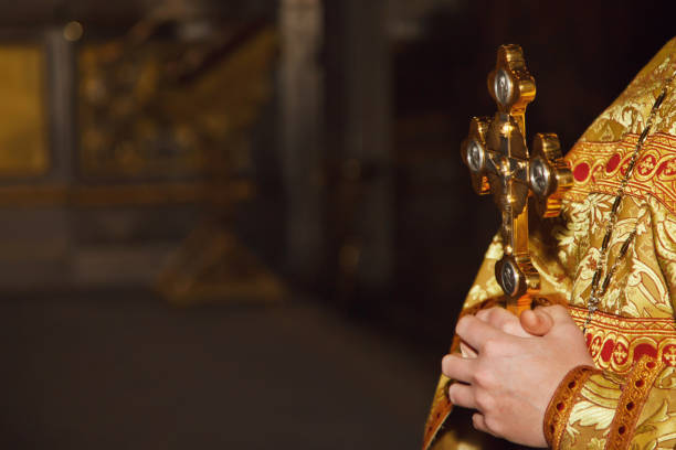 Rite of baptism golden cross in priest hands in orthodox church or temple for ceremony easter Rite of baptism golden cross in priest hands in orthodox church or temple for ceremony easter. Background cross easter in orthodox temples. Concept of church backgrounds for creativity. Copy space orthodox church easter stock pictures, royalty-free photos & images