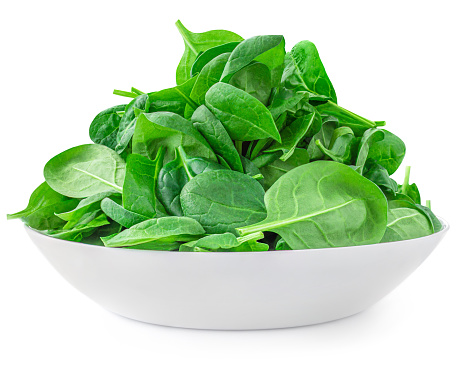 Fresh Spinach leaves on a plate isolated on white background. Green spinach lunch. Healthy diet eating concept
