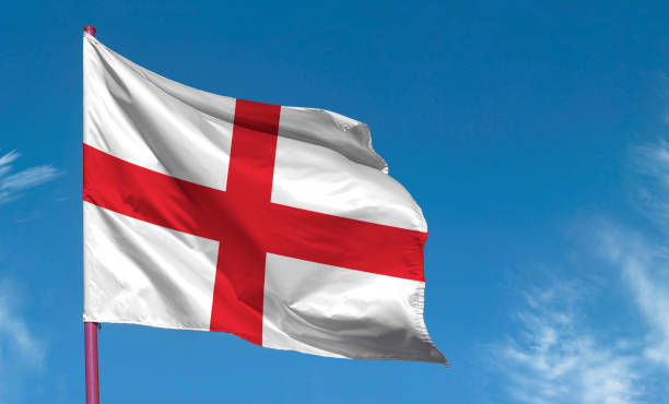 флаг англии на фоне голубого неба - святой george стоковые фото и изображения