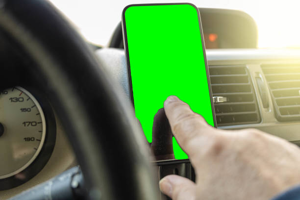 istock selective focus detail of a man using the mobile phone inside the vehicle while driving read and send messages schedule route or activate calls from the mobile image by Croma in Concept road safety 1312933325