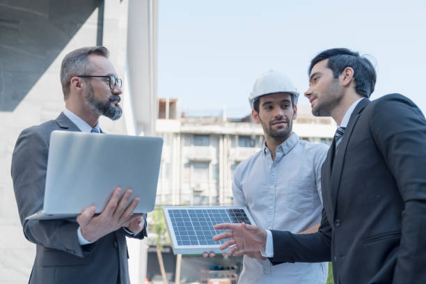 istock Businessman present new ecology project. around solar panel for roof. Hand holding a solar panel. 1312944944