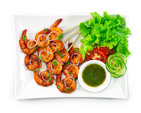 Tandoori Shrimps Grilled Skewers served Mint Sauce is a classic Indian dinner that marinates Shrimps wing in a creamy yogurt base, blended spice decorate with Onion,Lime and vegetable topview