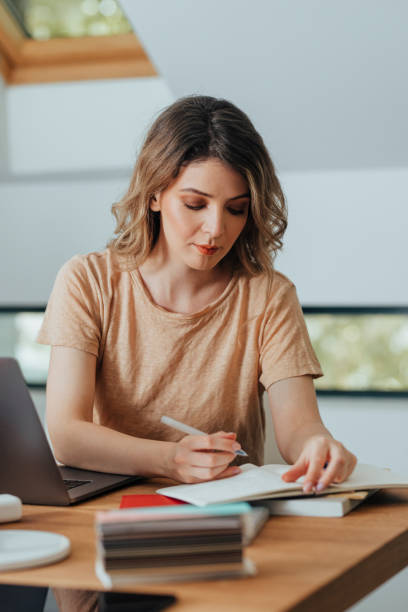 istock Beautiful Female Entrepreneur Working in Her Office: Writing Notes in her Agenda 1312953579