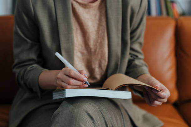 istock Anonymous Businesswoman in a Suit Writing Notes in Her Agenda 1312953593