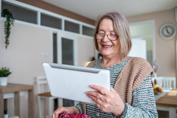istock An elderly woman reading a newspaper on a digital tablet and drinking her coffee. 1312954600