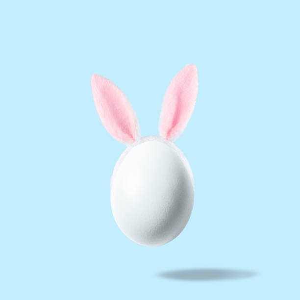 istock White egg with pink bunny ears against pastel blue background. Easter minimal concept. Creative Happy Easter or spring layout. 1312955717