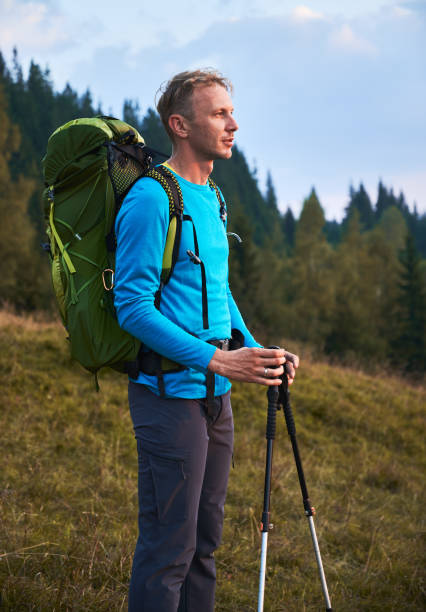 istock Lonely young man hiking with backpack outdoors. 1312960527