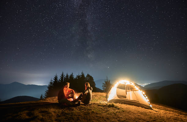 istock Romantic nightly camping in mountains under starfull sky. 1312962955