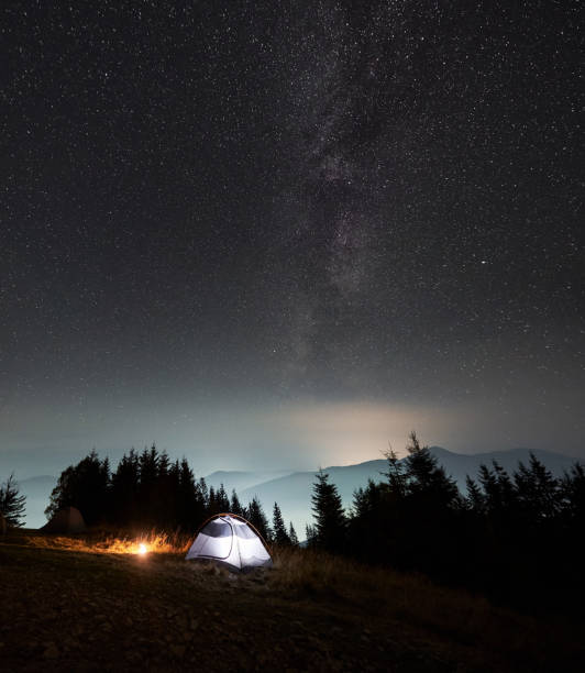 istock Illuminated camp tent under beautiful night sky with stars. 1312963032
