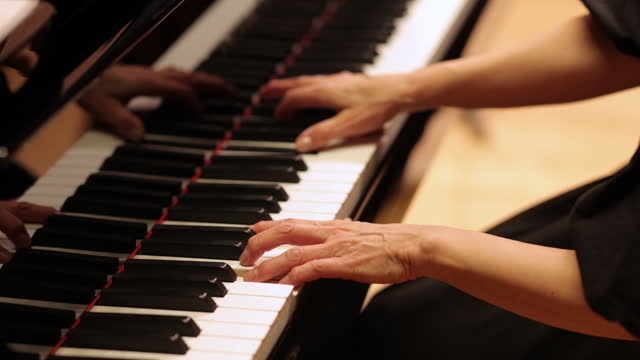 Close-up of female musician playing the piano at classical music concert