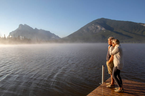 istock Mature couple relax by mountain lake edge 1312965228