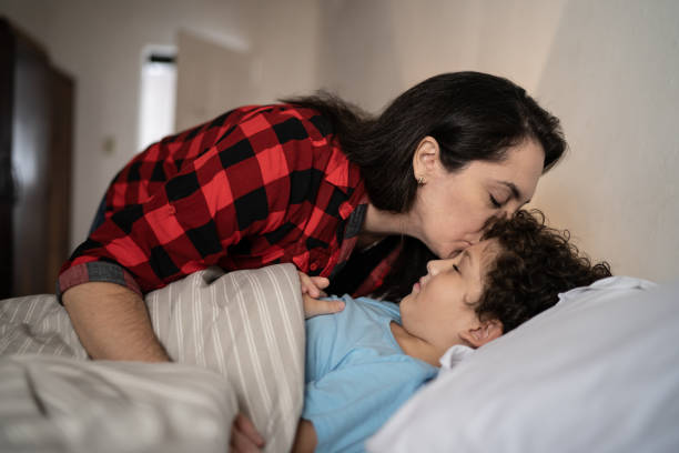 istock Mother putting son to sleep at home 1312969066
