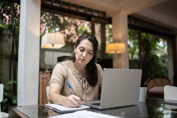 istock Woman using laptop working at home 1312969820