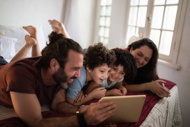 istock Family in bed watching something on digital tablet 1312969896