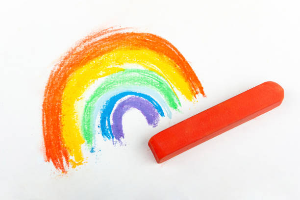 istock colorful rainbow drawing and red crayon on white background 1312971215