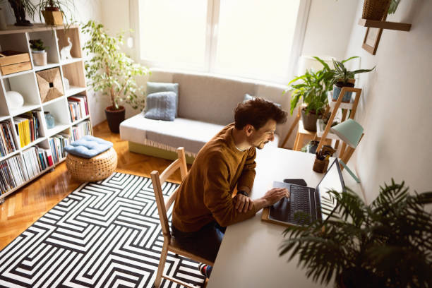 istock High angle view of a handsome young man using a laptop at home 1312971544