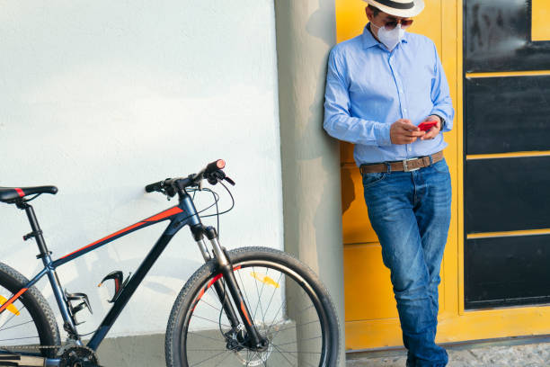 istock Businessman with protective mask checking his cell phone next to his bicycle 1312973925