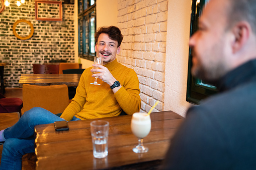 Two cheerful businessmen having a coffee break in a restaurant.