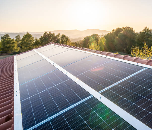 日落時分，房子屋頂上的太陽能電池板 - 太陽能�發電廠 個照片及圖片檔