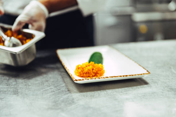 Professional chef platting Indian desert in a fine dining restaurant kitchen