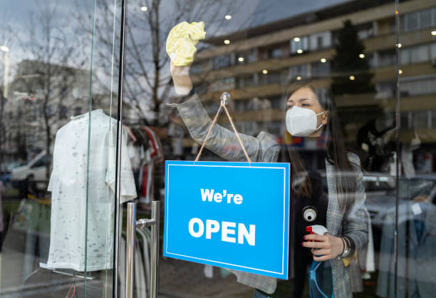 istock Smart shop Assistant disinfecting the doorway ready to welcome back customers, 1312981299
