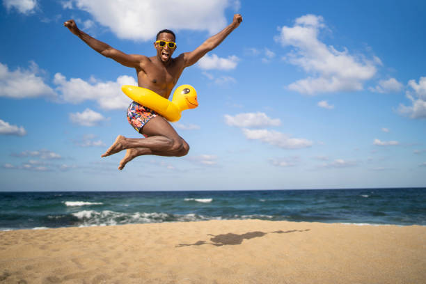 istock Brazilian young man jumping on an empty beach 1312982662