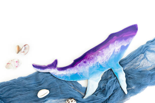 istock Resin art whale with fabric waves and sea shells on white. Flat lay 1312982804