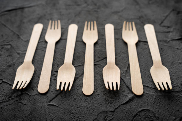 istock Wooden knife and fork on the black background. Eco friendly zero-waste concept. Top view with space for text. Copy space 1312984895
