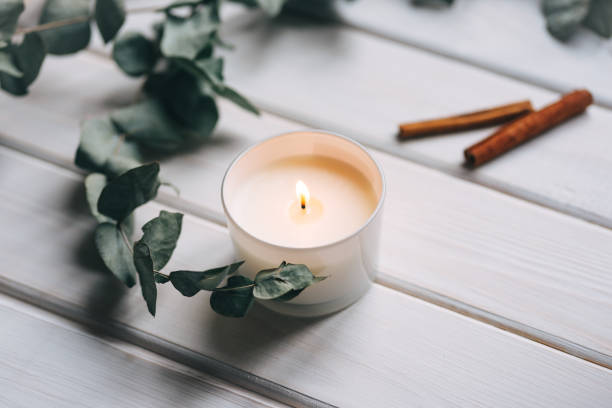 istock Candle, eucalyptus, cinnamon on white wooden background 1312985503