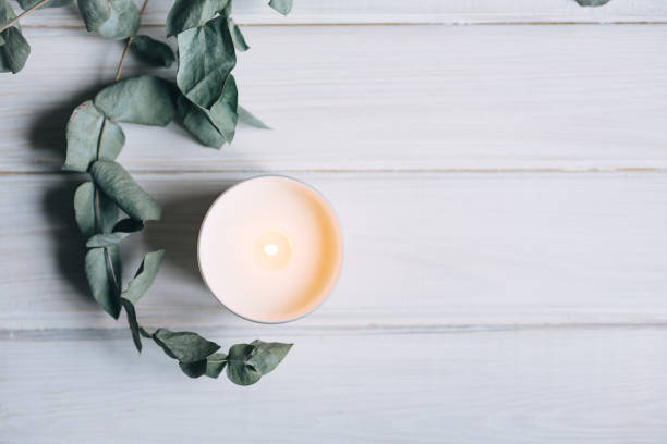 istock Candle and eucalyptus on white wooden background 1312985507