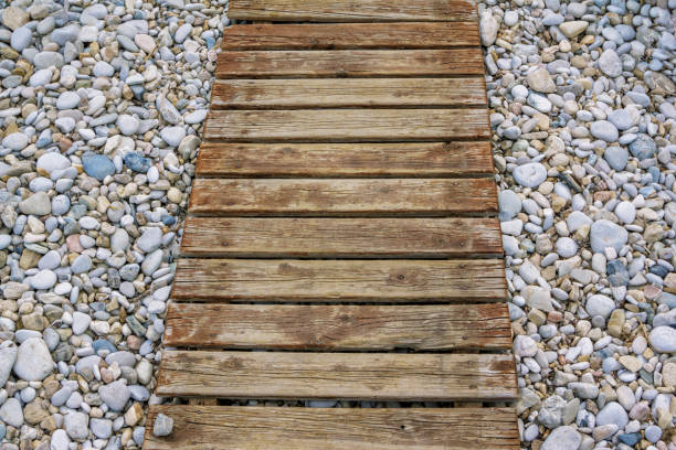Wooden walkway to sea on pebbles. Path on the beach.