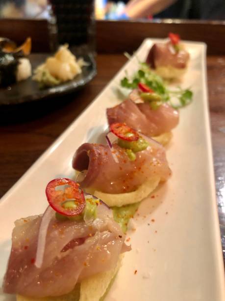 istock Delicious peruvian dish, tiraditos with white fish, crispy bread, avocado sauce, red onions and pepper 1312987494