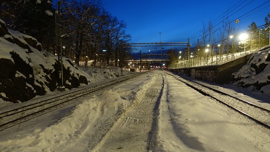 A large number of snow covered trains in a rail yard in winter.