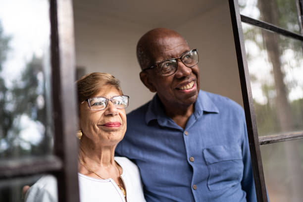 istock Senior couple looking through the window at home 1312988020