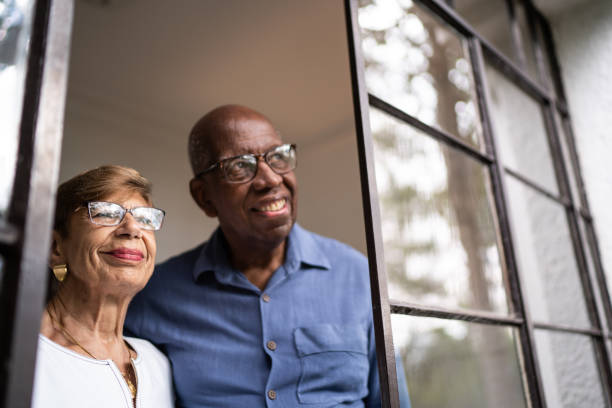 istock Senior couple looking through the window at home 1312988021