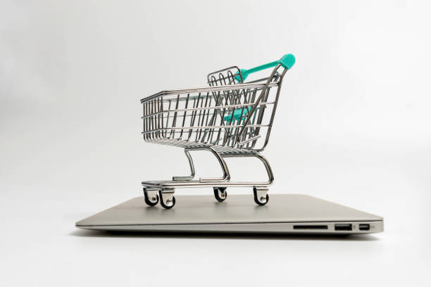 istock shopping cart on closed laptop isolated on white 1312992316