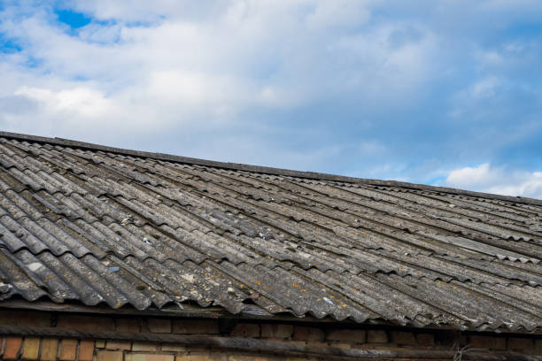 istock Old asbestos roof slates against blue sky. 1312992402