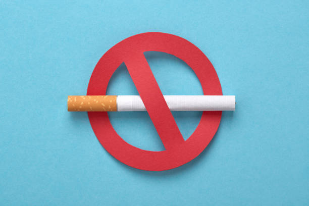 Red forbidden sign with a cigarette, No smoking concept. No smoking icon. Red forbidden sign with a cigarette on blue. No tobacco day, no smoking concept. conceptual realism photos stock pictures, royalty-free photos & images