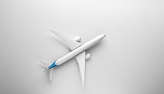 Travel concept with airplane toy over white background. Top view flat lay with copy space.