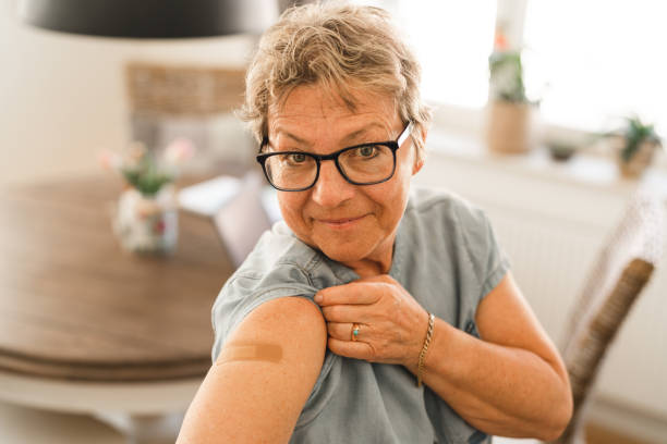 istock Senior woman showing that she has been vaccinated 1312998108