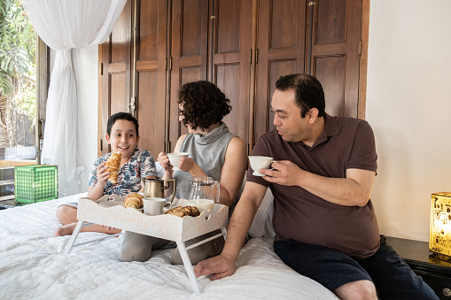 Family having breakfast in bed - person with disabilities