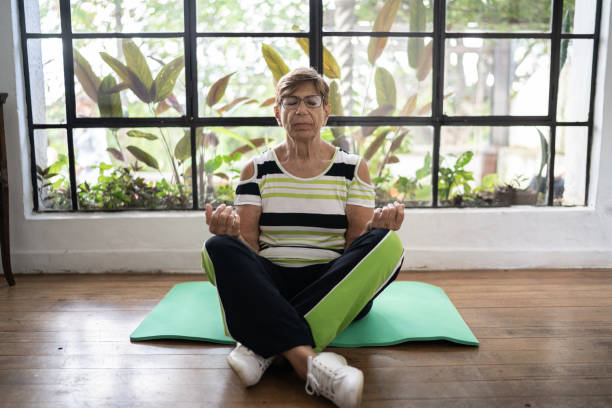 istock Senior woman meditating at home 1313000330