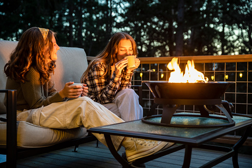 Girls hanging out by a propane fire pit